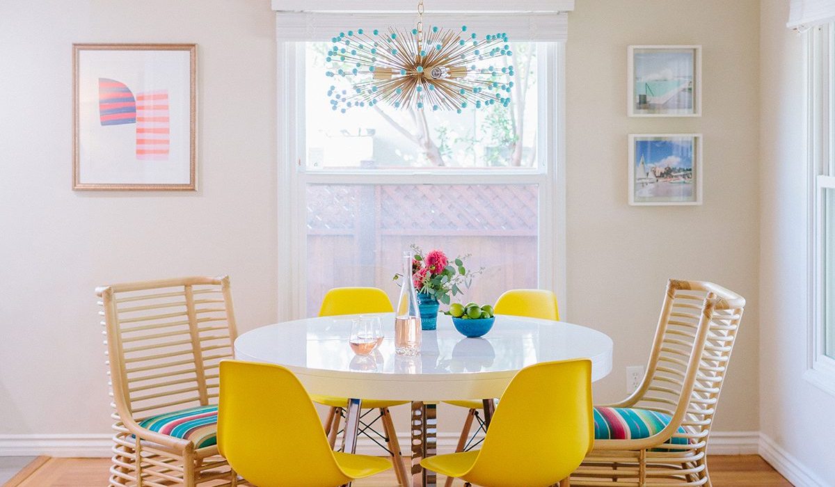 Yellow dining chairs paired with two brightly colored "spring" patterned cushioned chairs add nice pops of color in this Santa Monica dining room. Design by 1 Chic Retreat